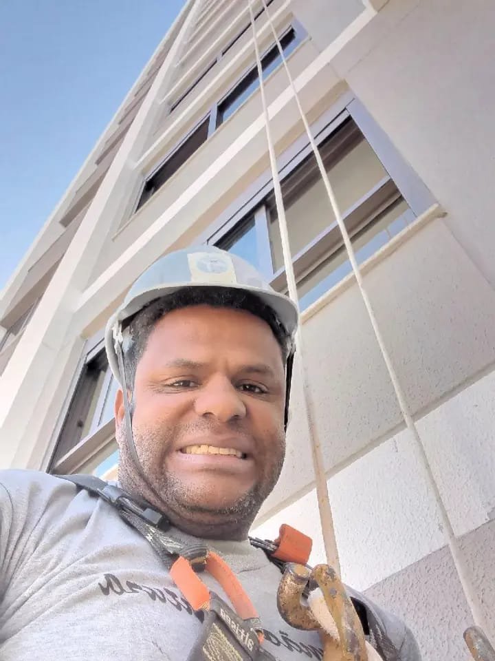 Selfie do pintor de rapel uniformizado demonstrando segurança na obra